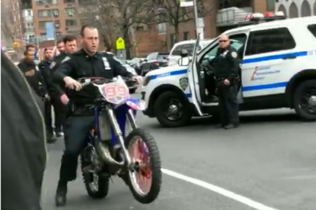 An NYPD officer rides a dirt bike in Harlem